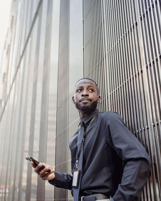 An employee with a lanyard badge against a modern facade