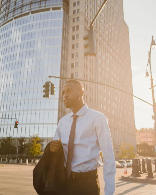 A consultant crossing a downtown street at golden hour