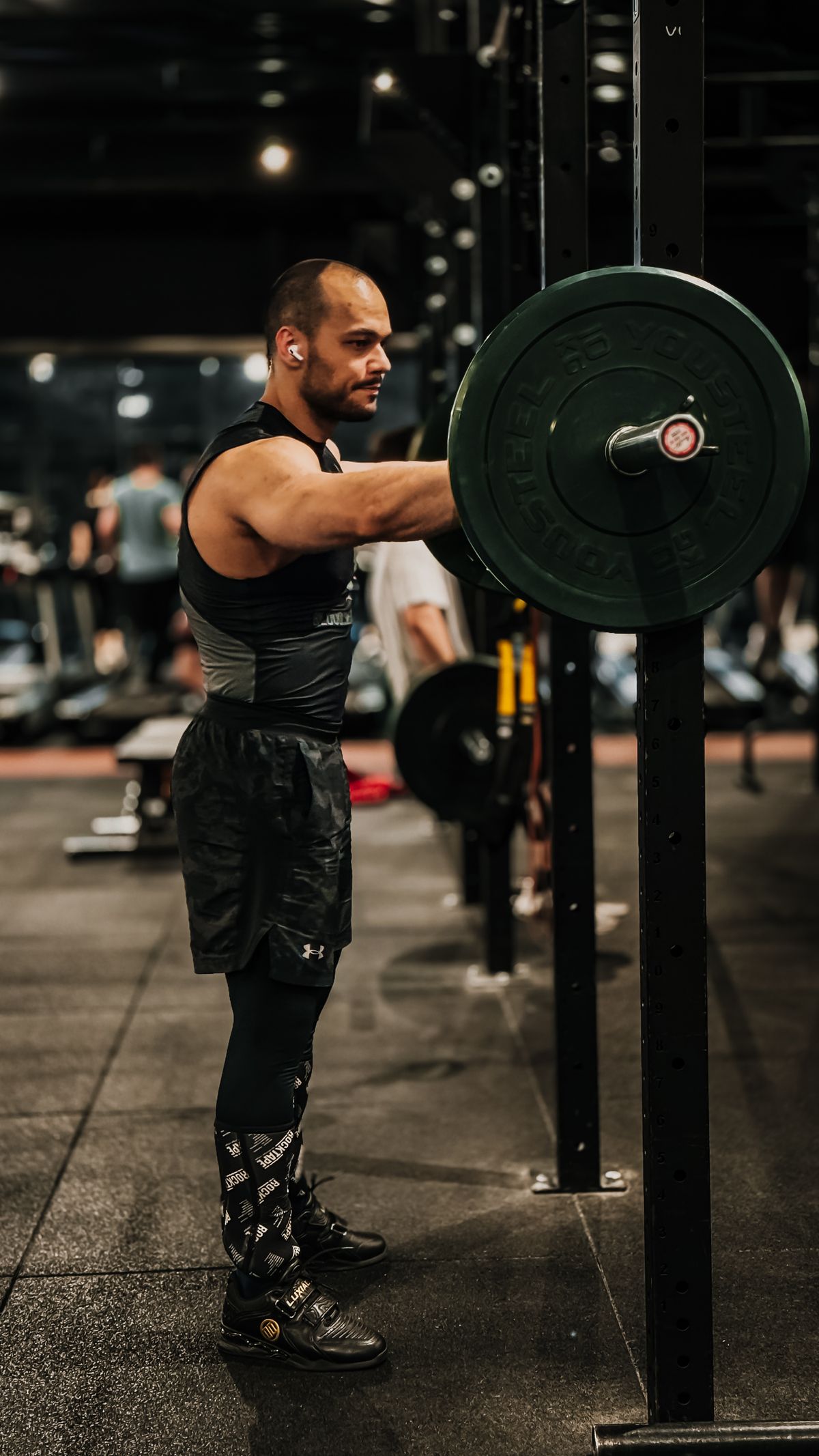 Loading a plate onto a barbell in a gym rack