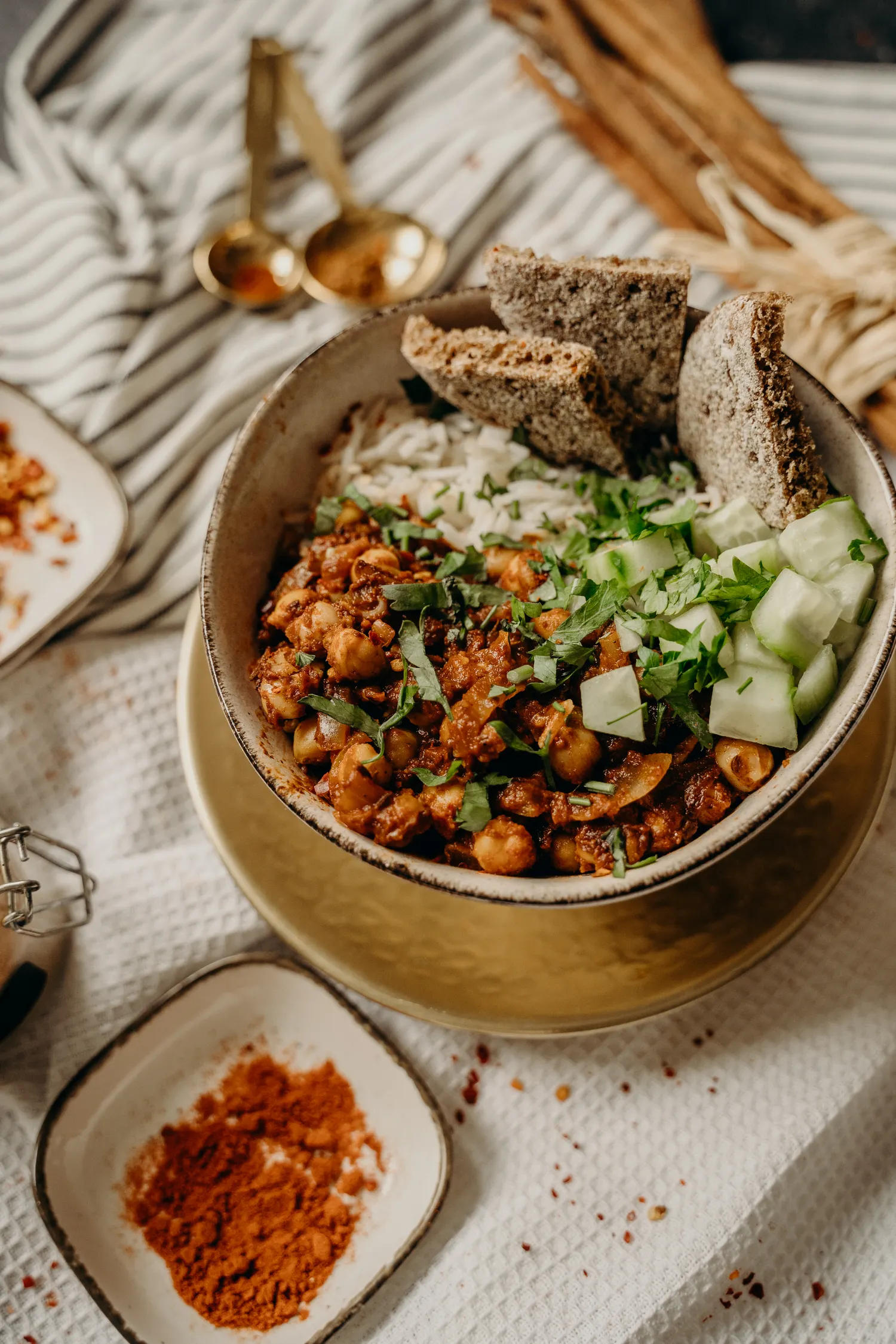 A bowl of chana masala with basmati rice and cucumber