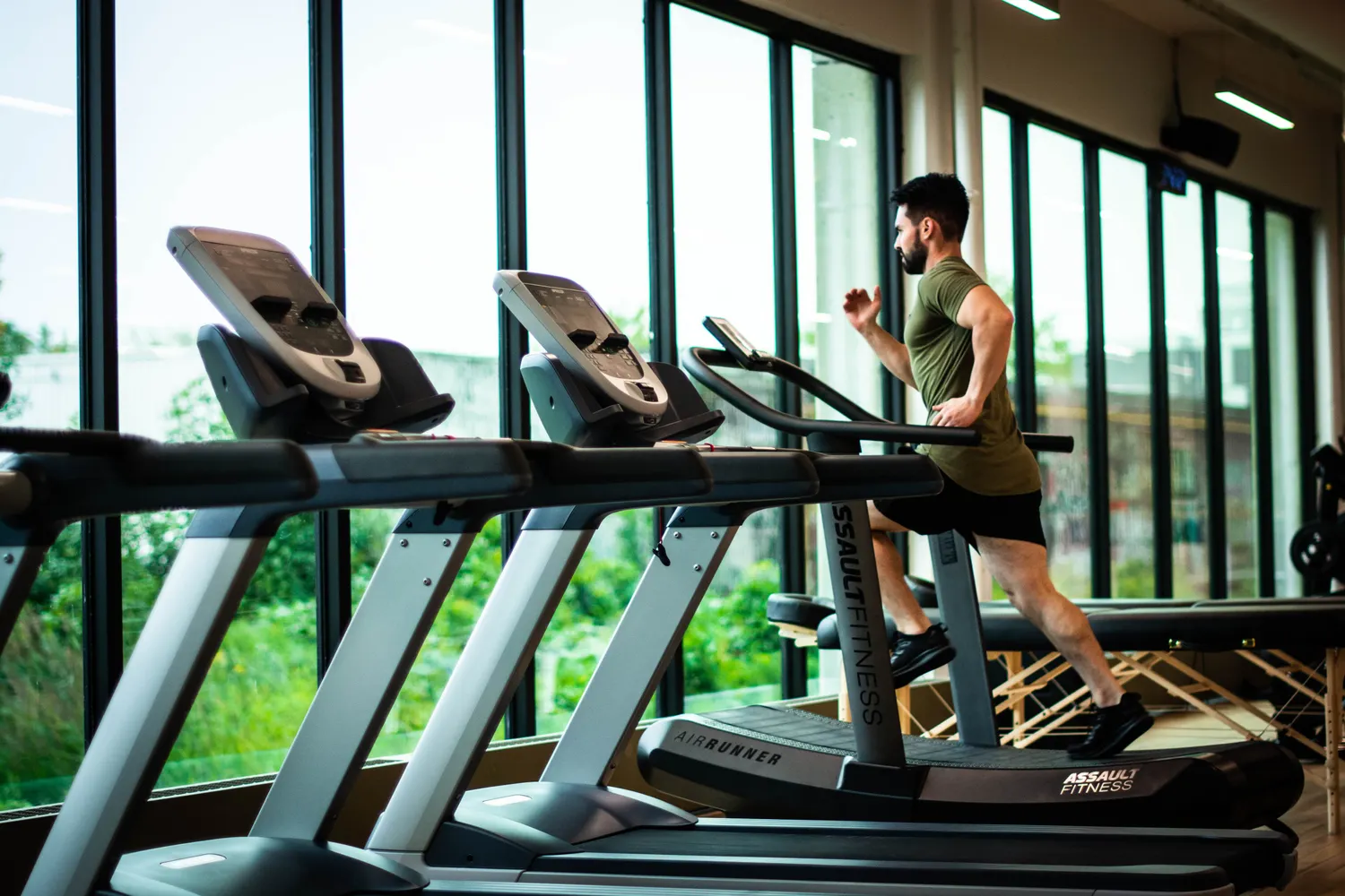 A hotel gym with floor-to-ceiling windows over the city