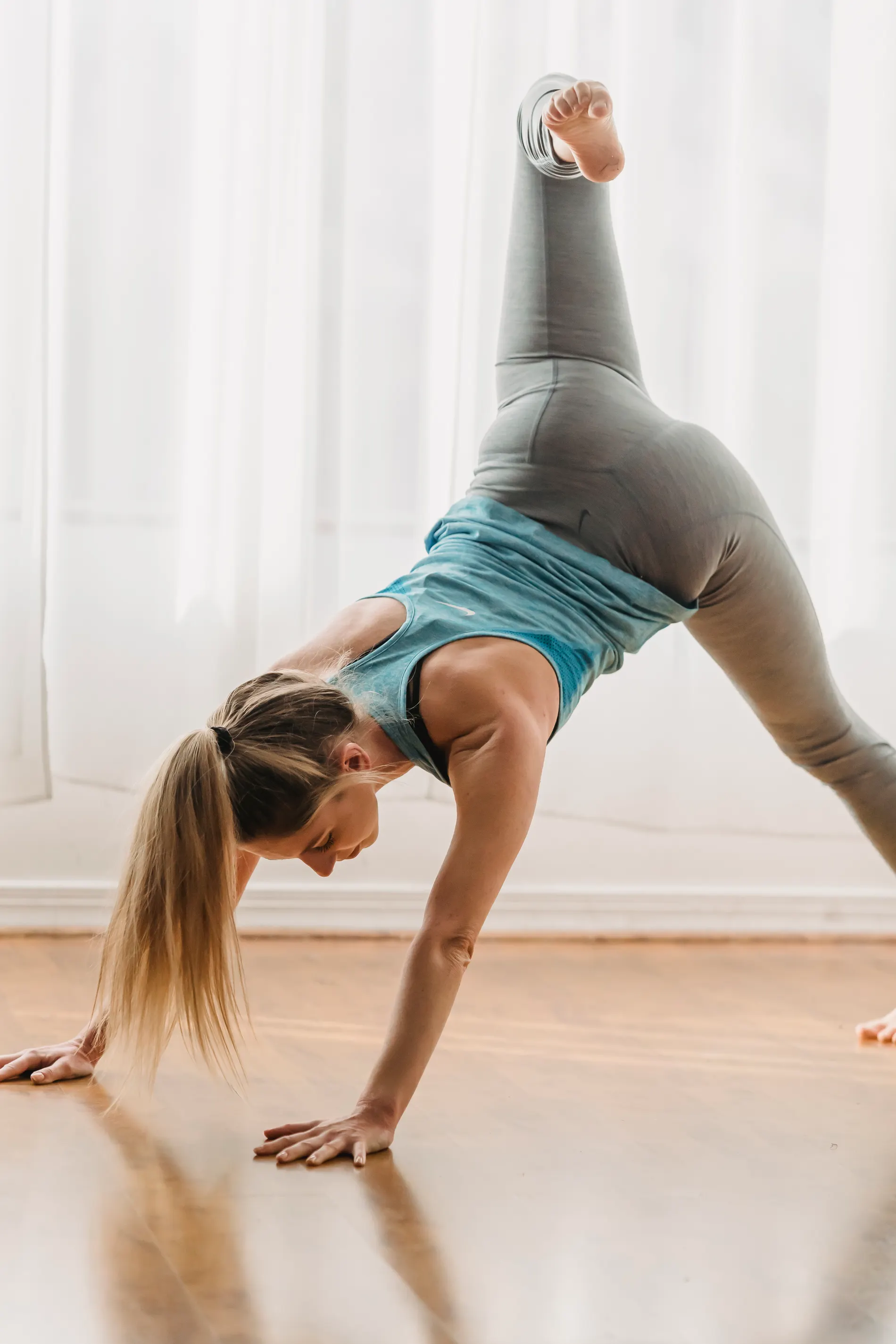 A woman holding a strong yoga position in a bright studio